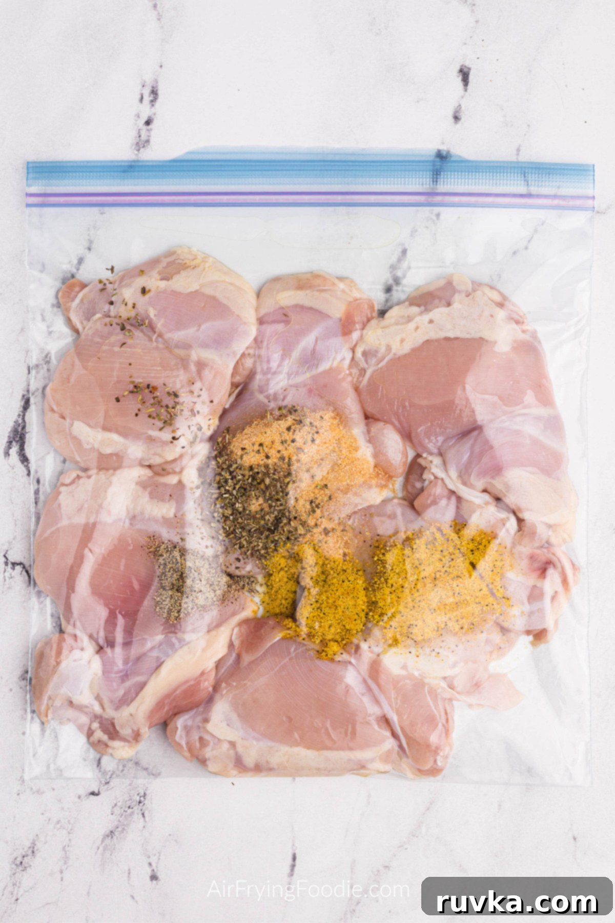 Crispy Air Fryer Lemon Pepper Chicken Thighs 5 Chicken thighs in a plastic bag, fully coated with lemon pepper seasoning and other spices.
