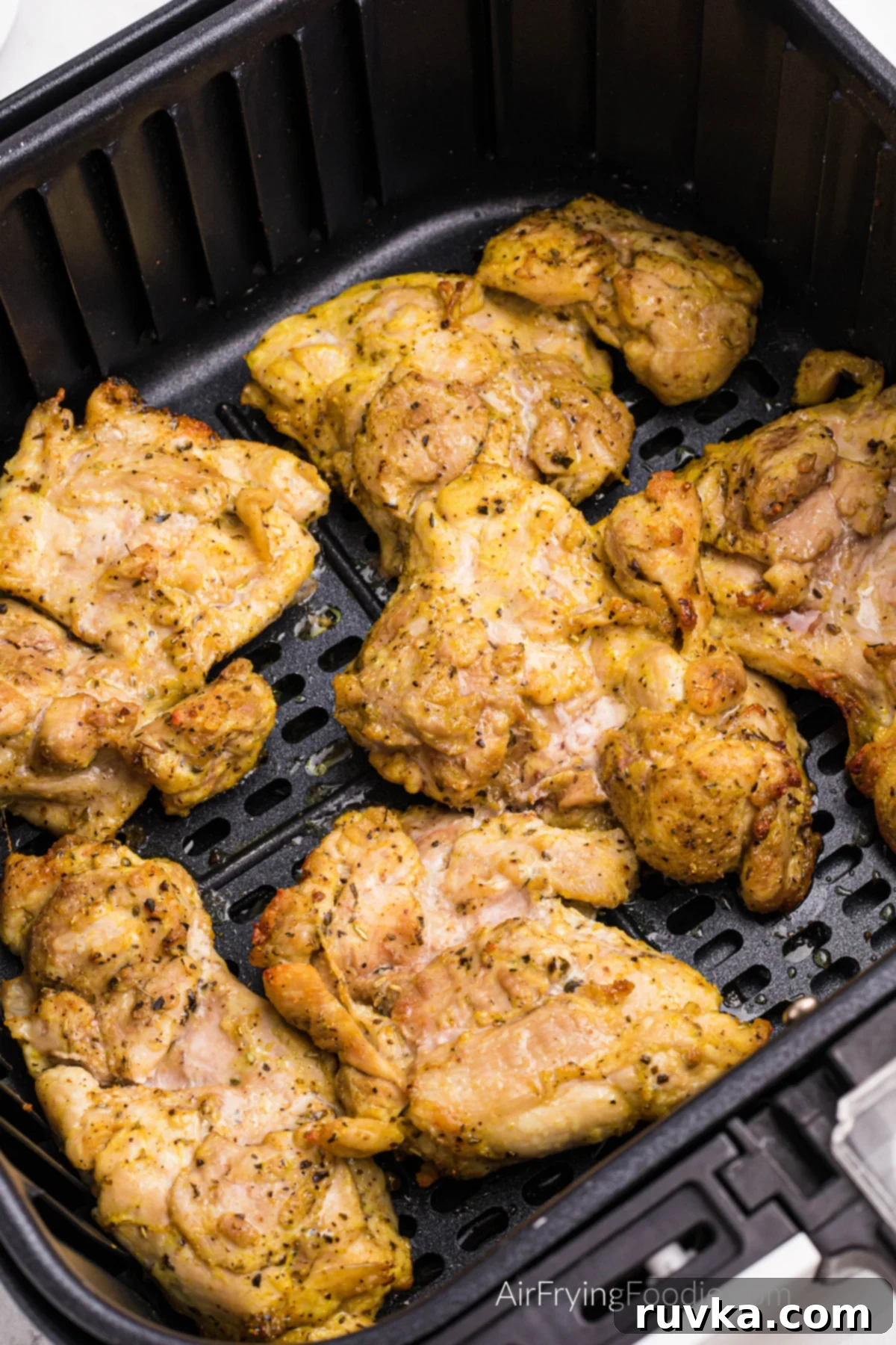 Crispy Air Fryer Lemon Pepper Chicken Thighs 7 Perfectly cooked lemon pepper chicken thighs in the air fryer basket, golden brown and ready to serve.