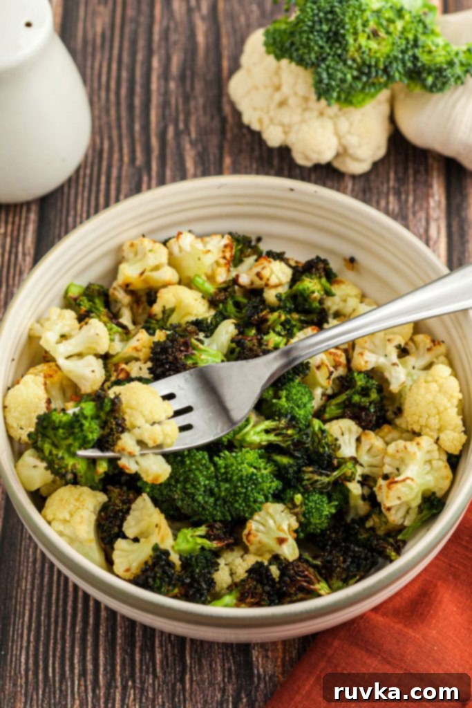 Crispy Air Fried Broccoli Cauliflower 7 A cream bowl filled with broccoli and cauliflower florets with a fork in the bowl