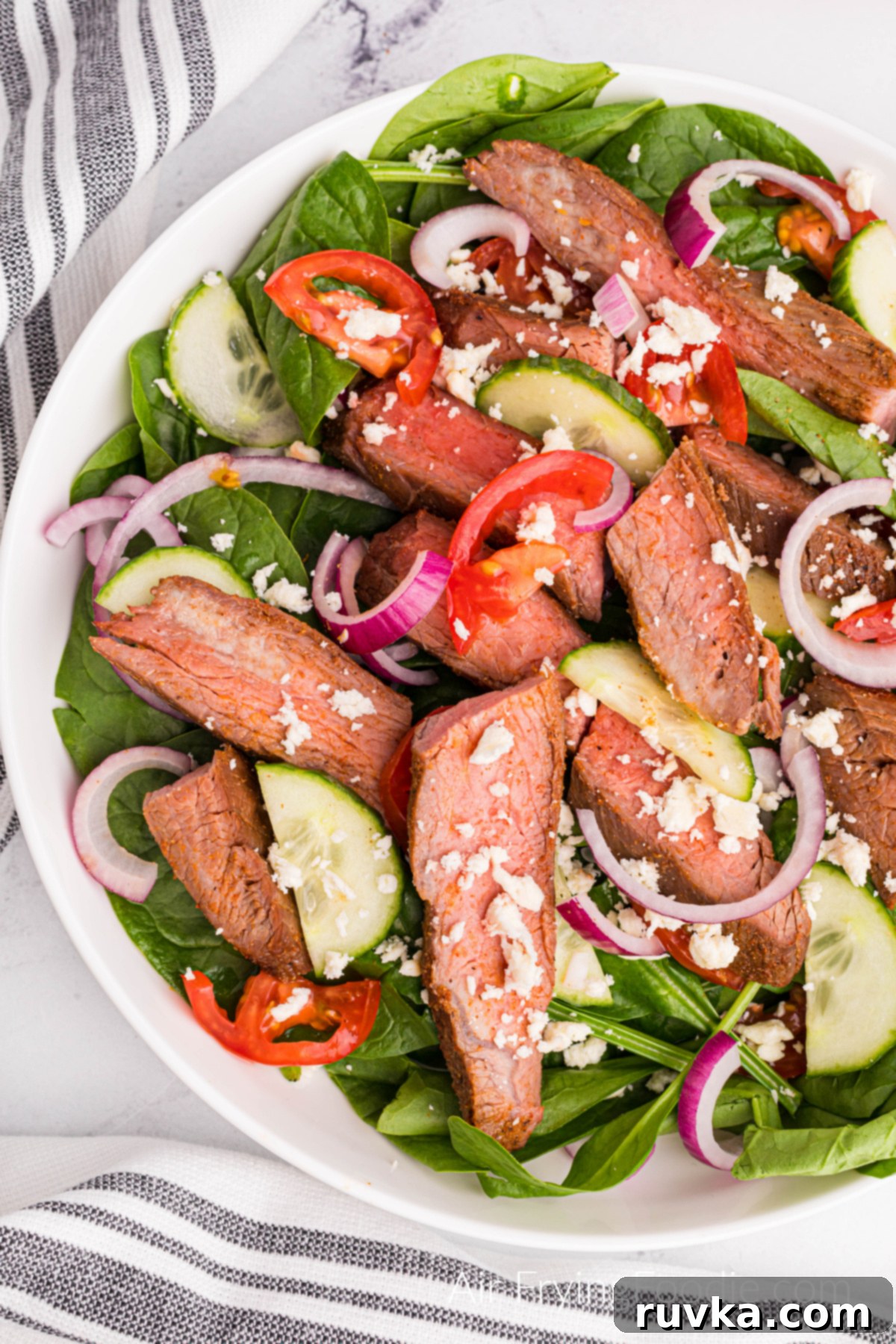 Perfect Air Fryer Flank Steak 2 Air Fried Flank Steak sliced and served on a salad.