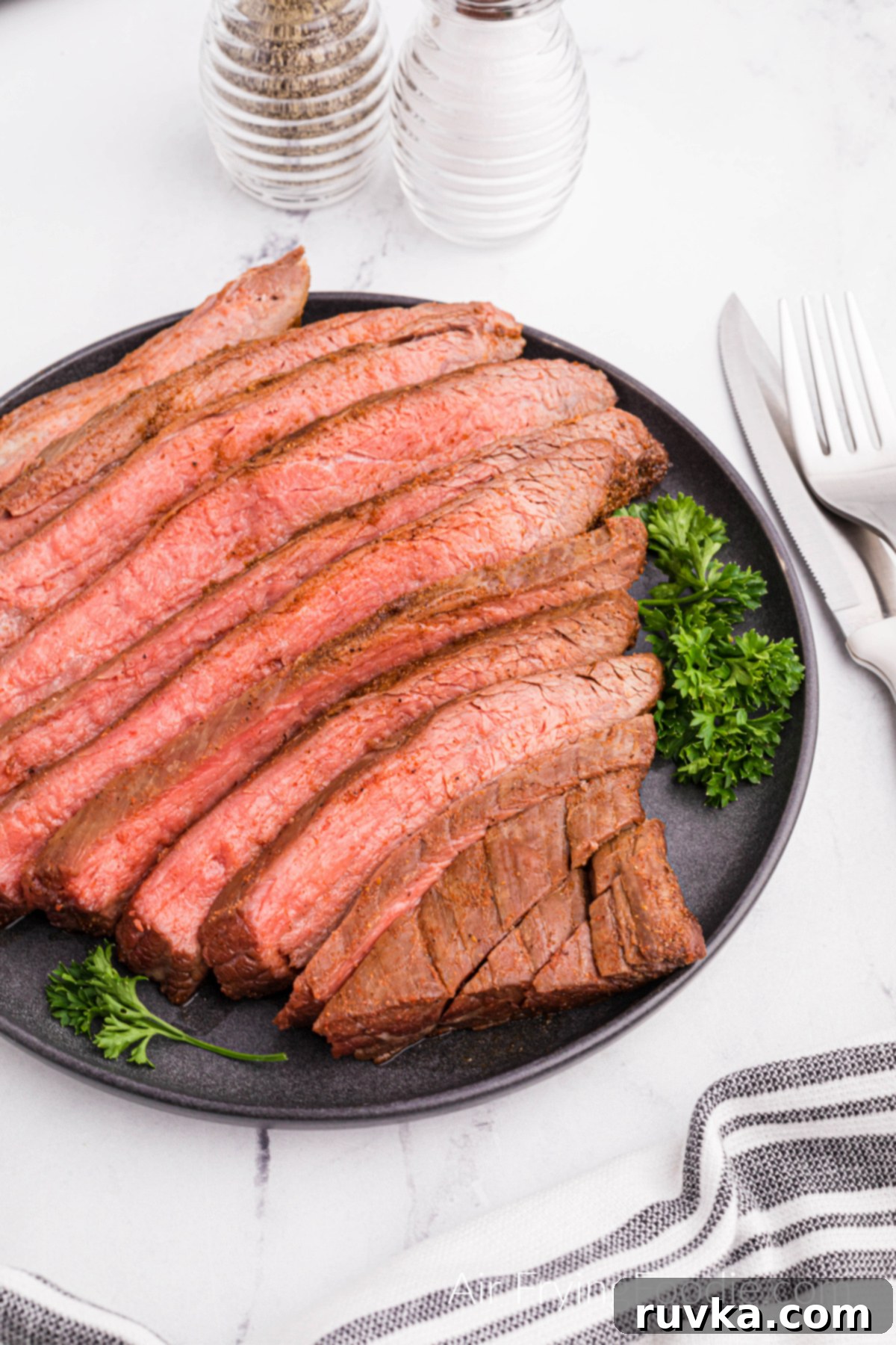 Perfect Air Fryer Flank Steak 12 Flank steak air fried, sliced, and served on a platter.