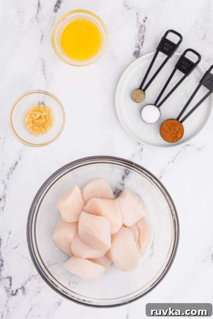 Crispy Air Fryer Scallops 3 Ingredients of scallops, garlic, and seasonings on a white marble table