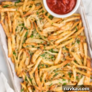 Crispy Air Fryer Truffle Fries 12 Overhead shot of truffle fries on a serving platter with a side of ketchup in a bowl.
