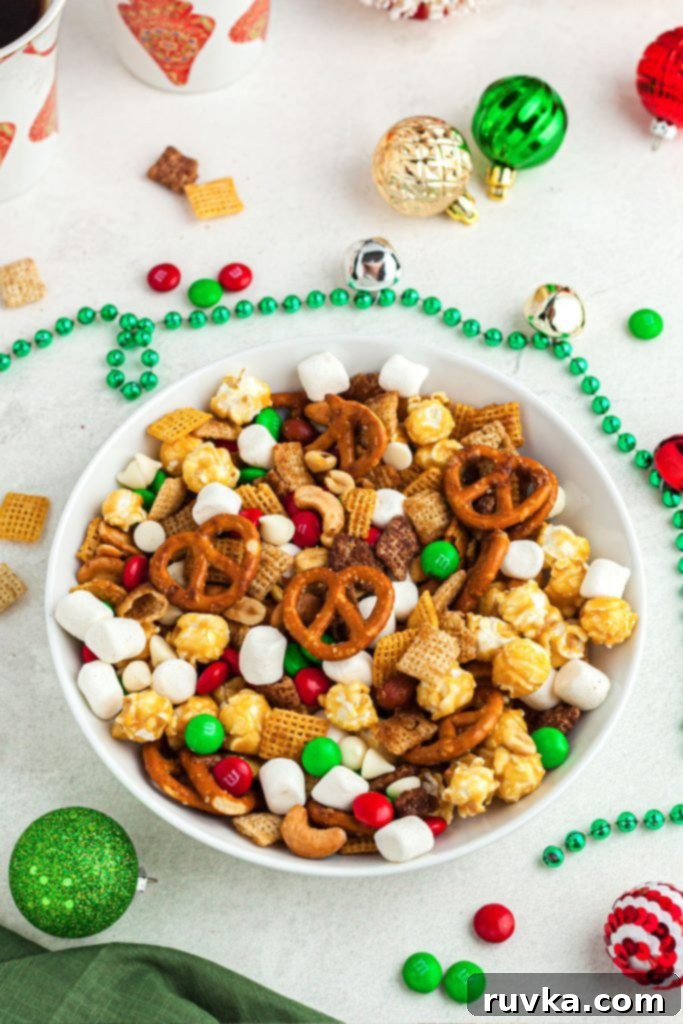 Crispy Air Fryer Reindeer Chow 2 Pretzels, marshmallows, candies and nuts mixed in a white bowl after being air fried