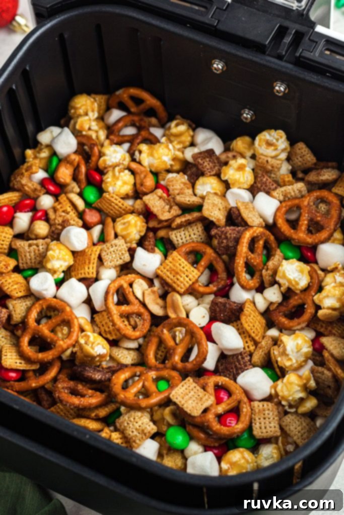 Crispy Air Fryer Reindeer Chow 8 Candies, marshmallows, and cereals mixed together in an air fryer basket