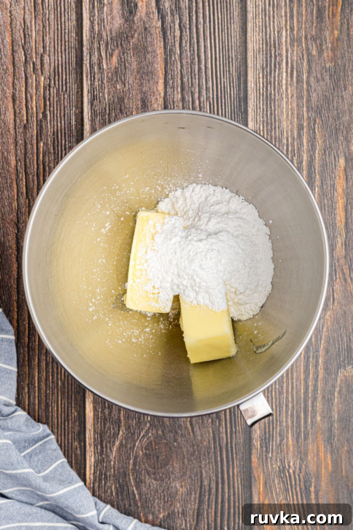 Butter and powdered sugar being mixed together in a bowl