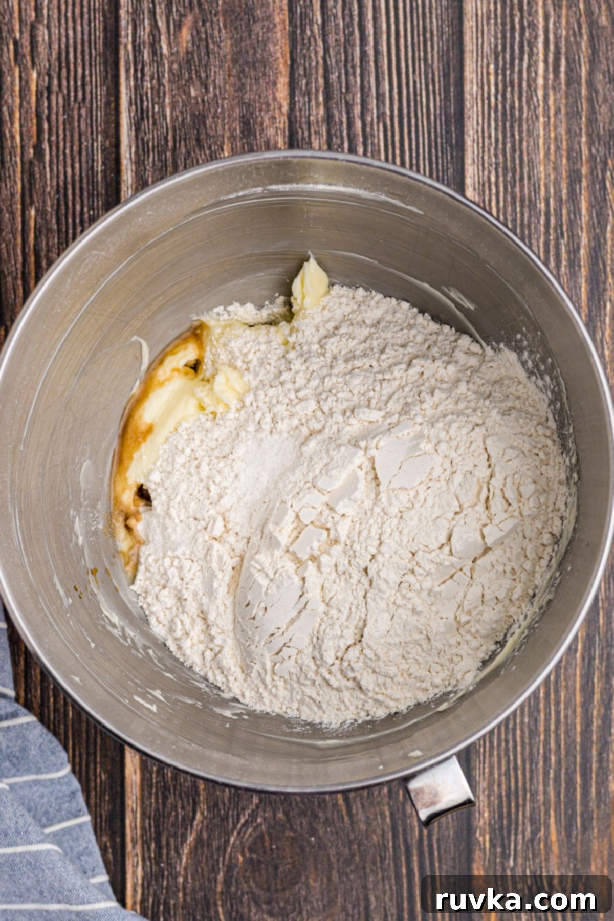 Dough forming in a mixing bowl with flour, vanilla, and salt