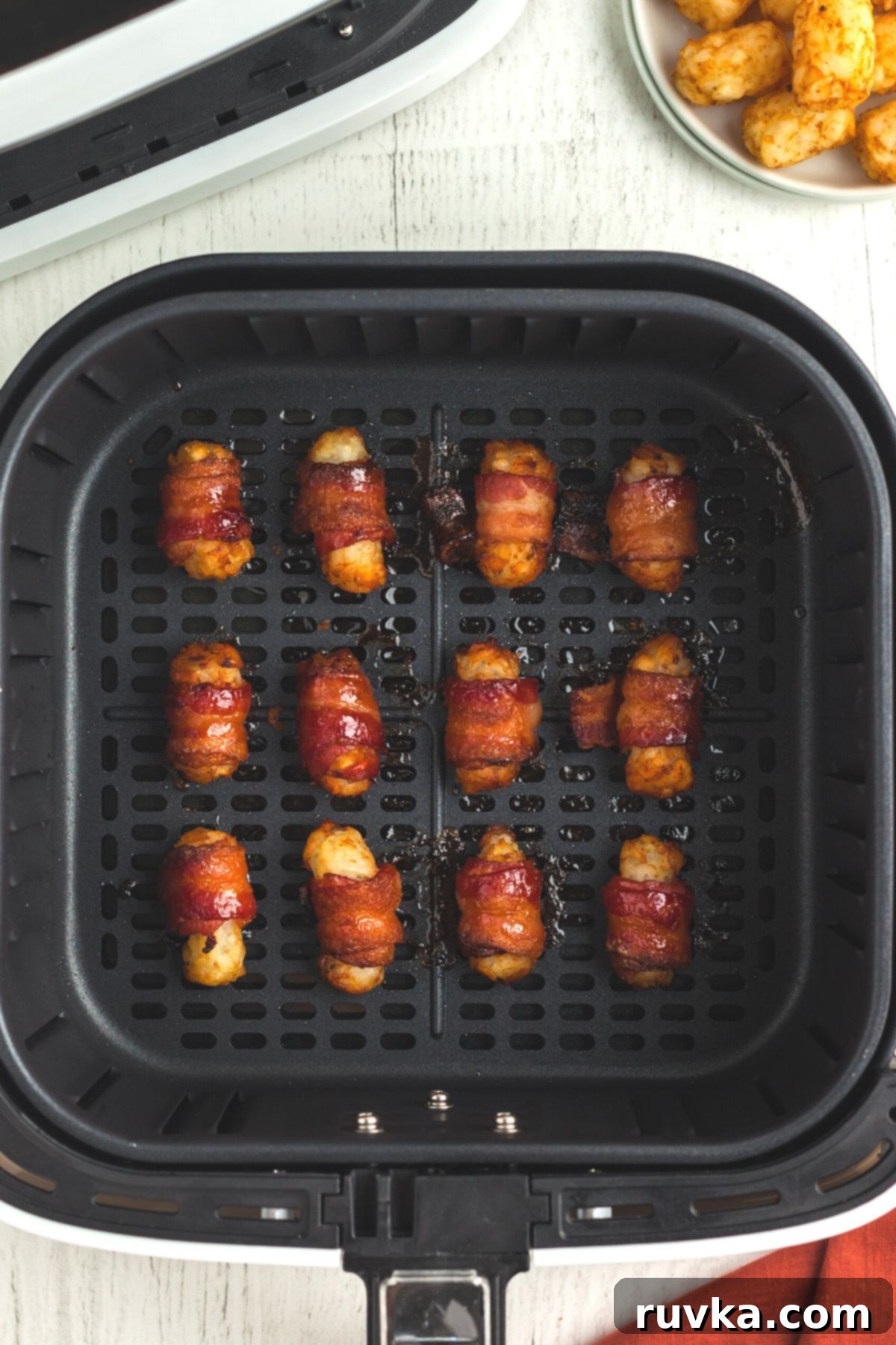Crispy Air Fryer Bacon-Wrapped Tater Tots 8 Crispy bacon wrapped tater tots in the air fryer basket
