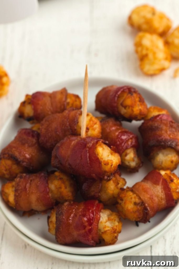 Crispy Air Fryer Bacon-Wrapped Tater Tots 10 Small white plate with golden crispy bacon wrapped tater tots