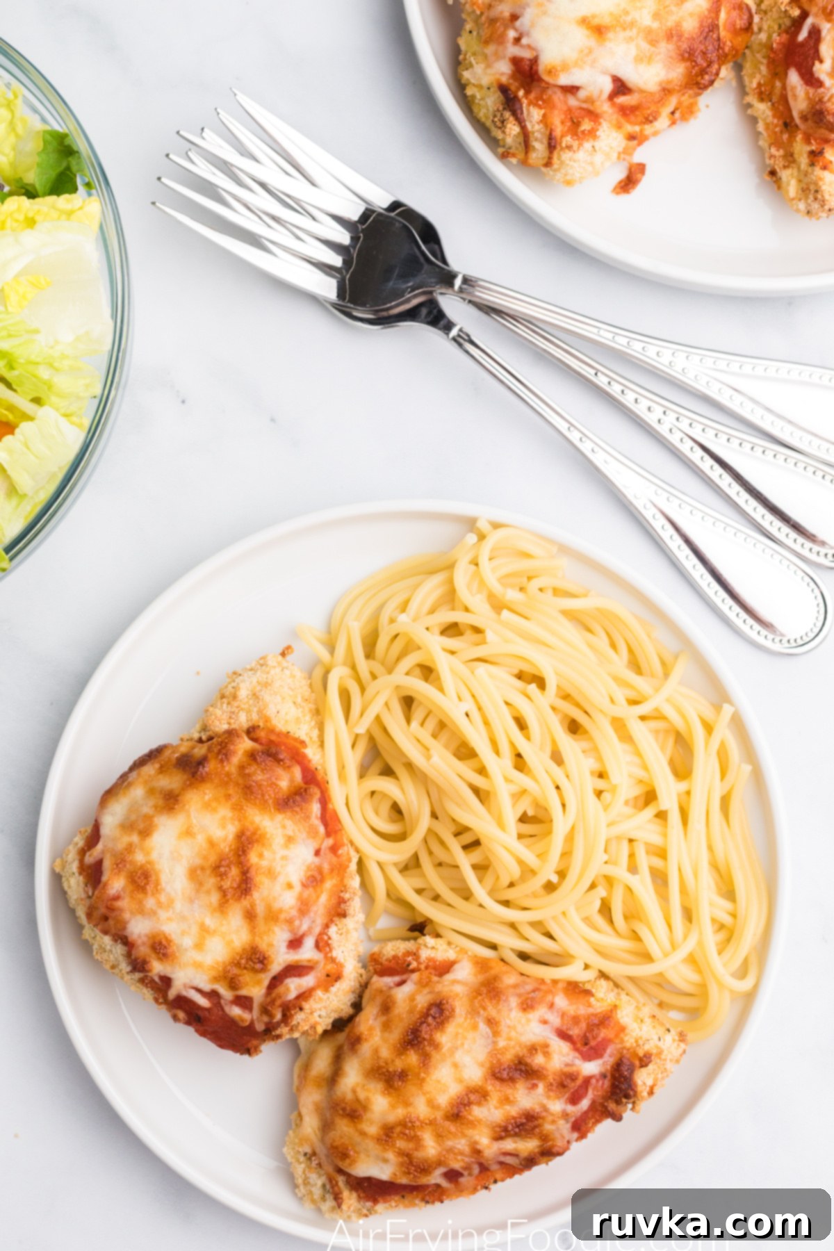 Crispy Air Fryer Chicken Parmesan 2 Overhead photo of chicken parmesan made in air fryer on a plate with spaghetti noodles.