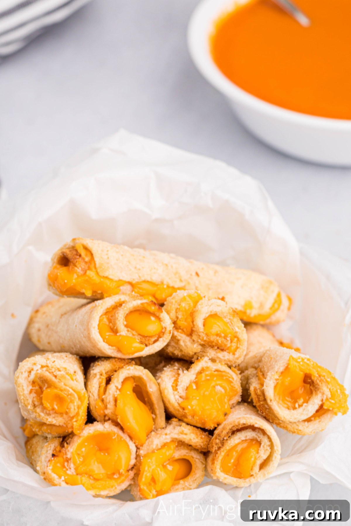 Crispy Cheesy Air Fryer Roll Ups 9 Grilled cheese roll ups cooked in the air fryer and ready to serve with a side of tomato soup.