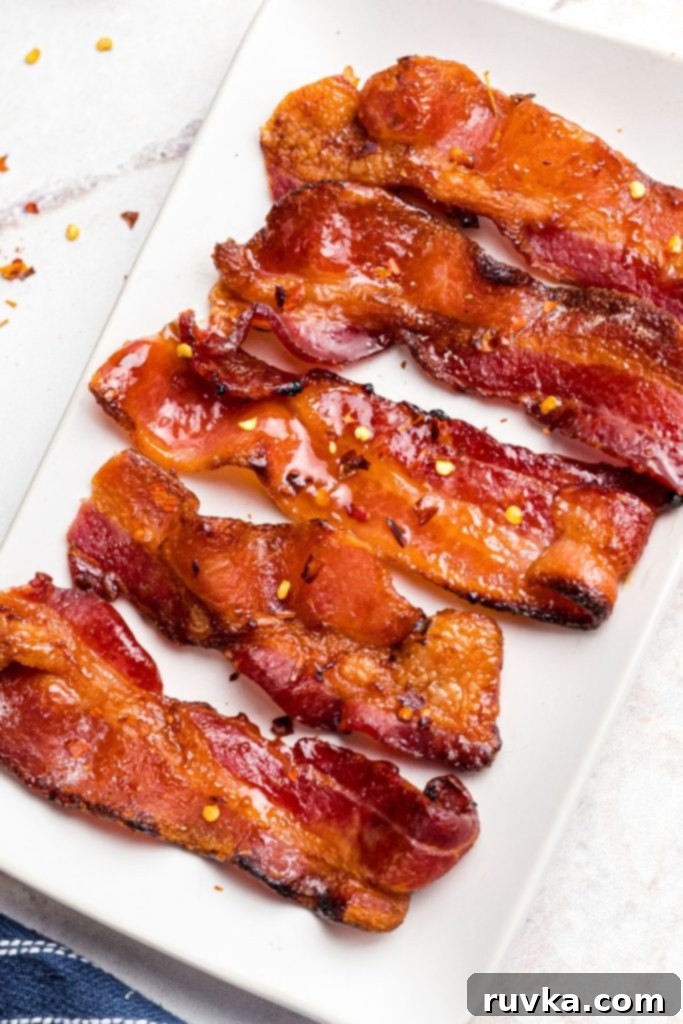 Crispy Sweet Air Fryer Bacon 7 Crispy and juicy carnalized bacon slices on a white plate