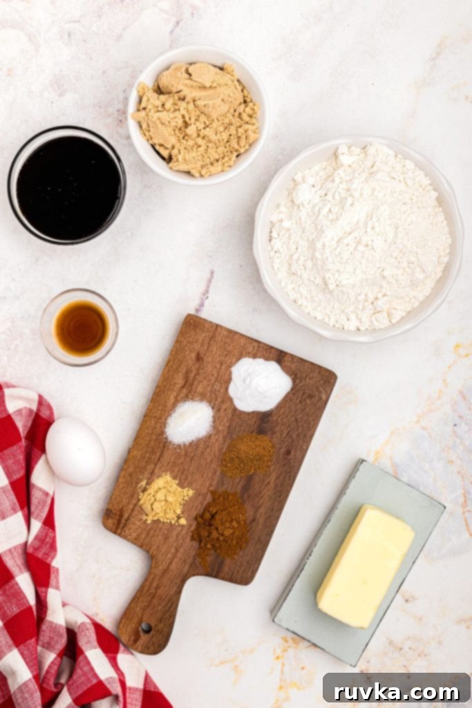 Quick and Easy Air Fryer Gingerbread Delights 4 Neatly measured ingredients for gingerbread cookies, including flour, spices, sugar, and butter, arranged on a marble table with a festive red linen.