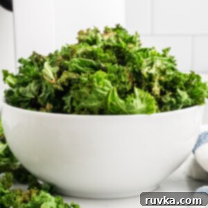 Crispy Air Fryer Kale Chips 11 Kale chips are fully cooked in the air fryer and served in a round white bowl.