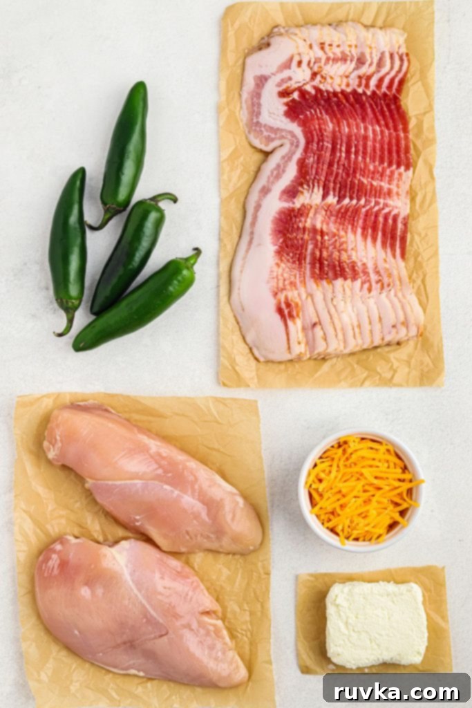 Crispy Air Fryer Chicken Jalapeno Poppers 3 Uncooked bacon and chicken with jalapenos and cheeses on a white table
