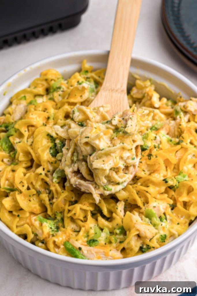 Crispy Air Fryer Chicken Casserole 9 A spoonful of cheesy pasta on a wooden spoon, showcasing the creamy texture and melted cheese.