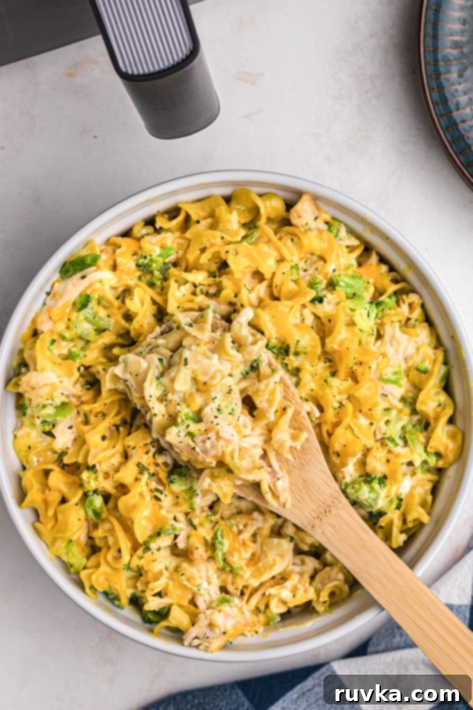 Crispy Air Fryer Chicken Casserole 10 A spoonful of creamy cheesy pasta with chicken in a casserole dish, ready to be served and enjoyed.