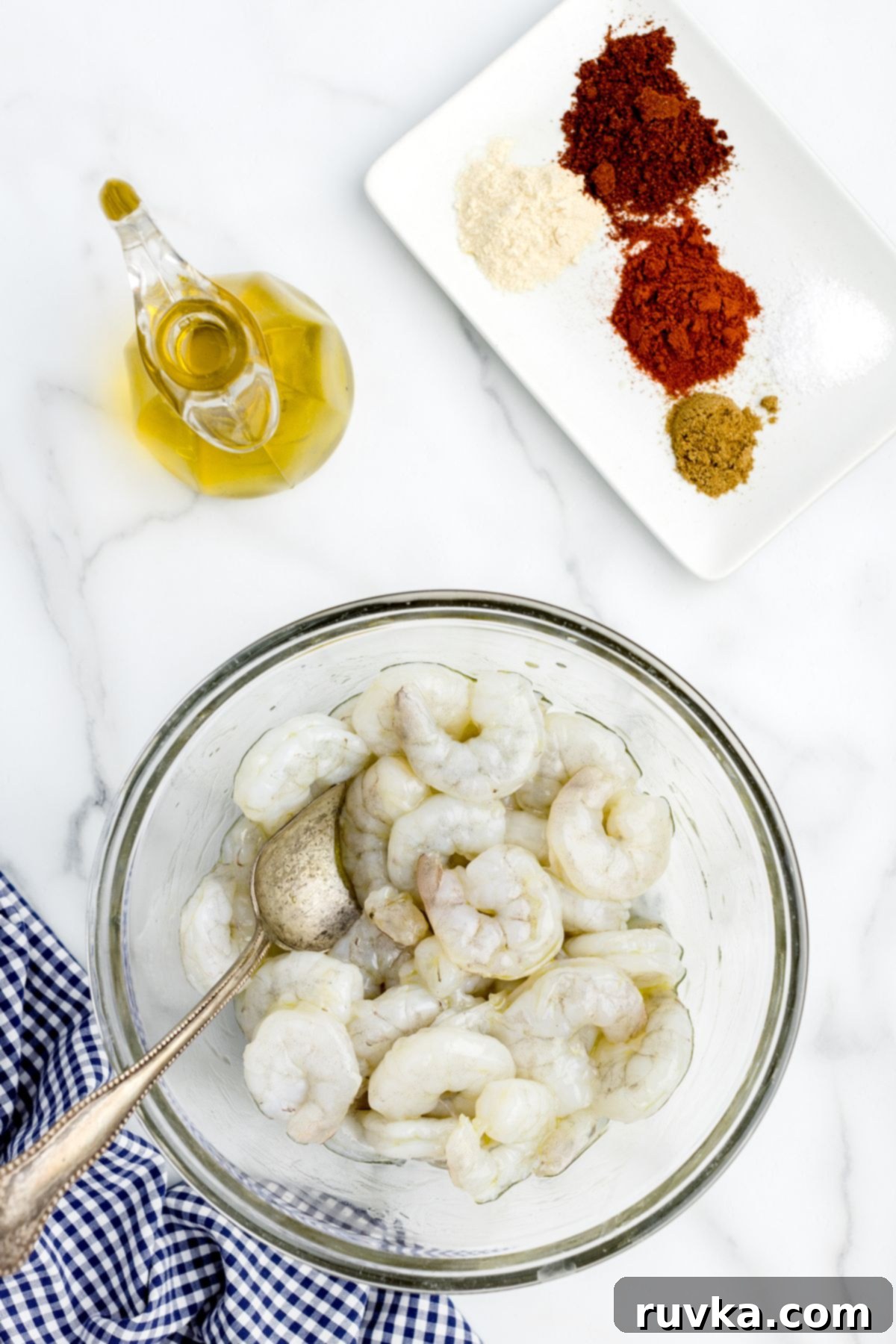 Crispy Air Fryer Shrimp Tacos 4 Uncooked shrimp in a clear glass bowl tossed with olive oil, ready for seasoning.