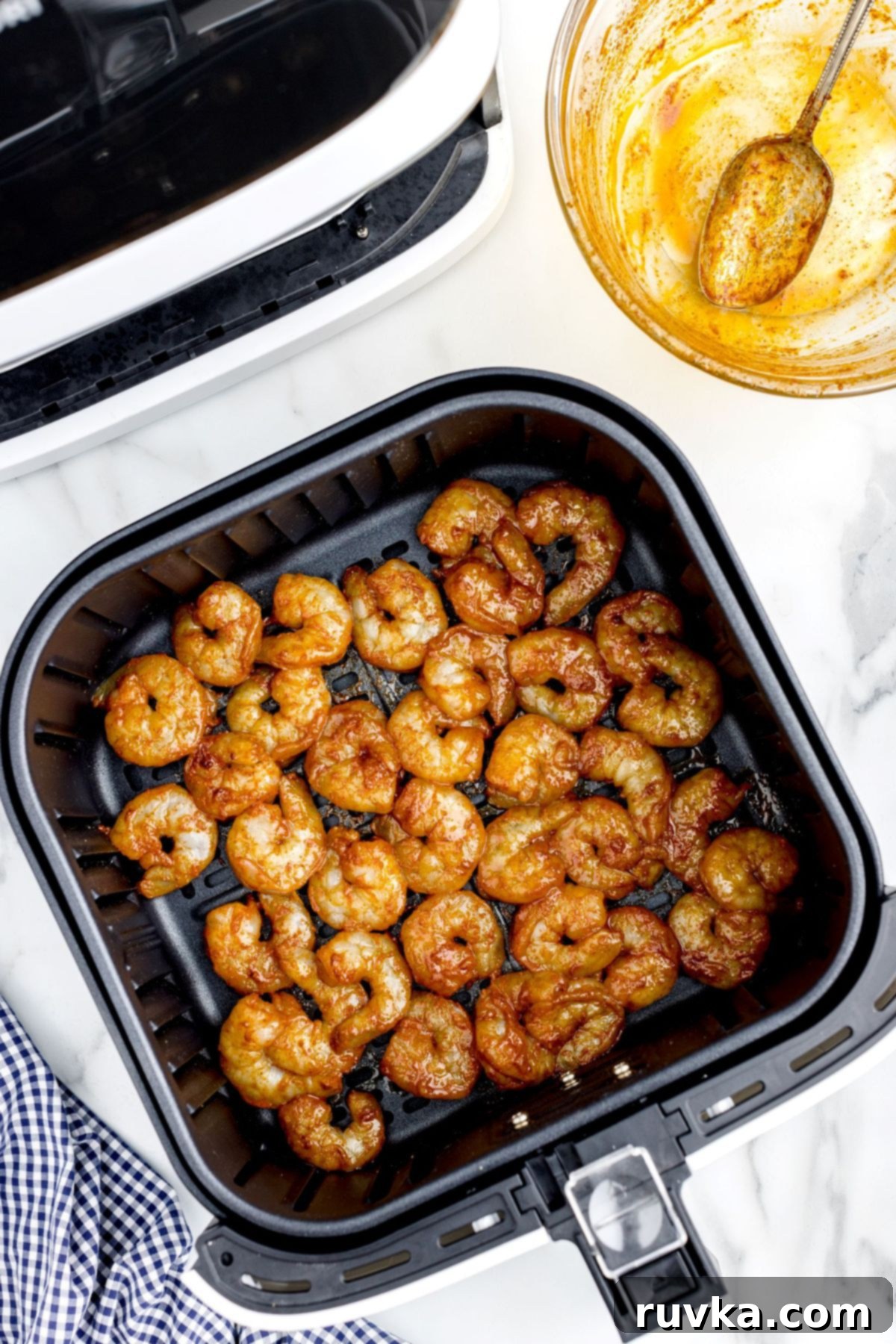 Crispy Air Fryer Shrimp Tacos 6 Seasoned shrimp in the air fryer basket before being cooked, arranged in a single layer.