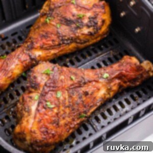 Crispy Air Fryer Turkey Legs 9 Golden brown crispy turkey legs in the air fryer basket.
