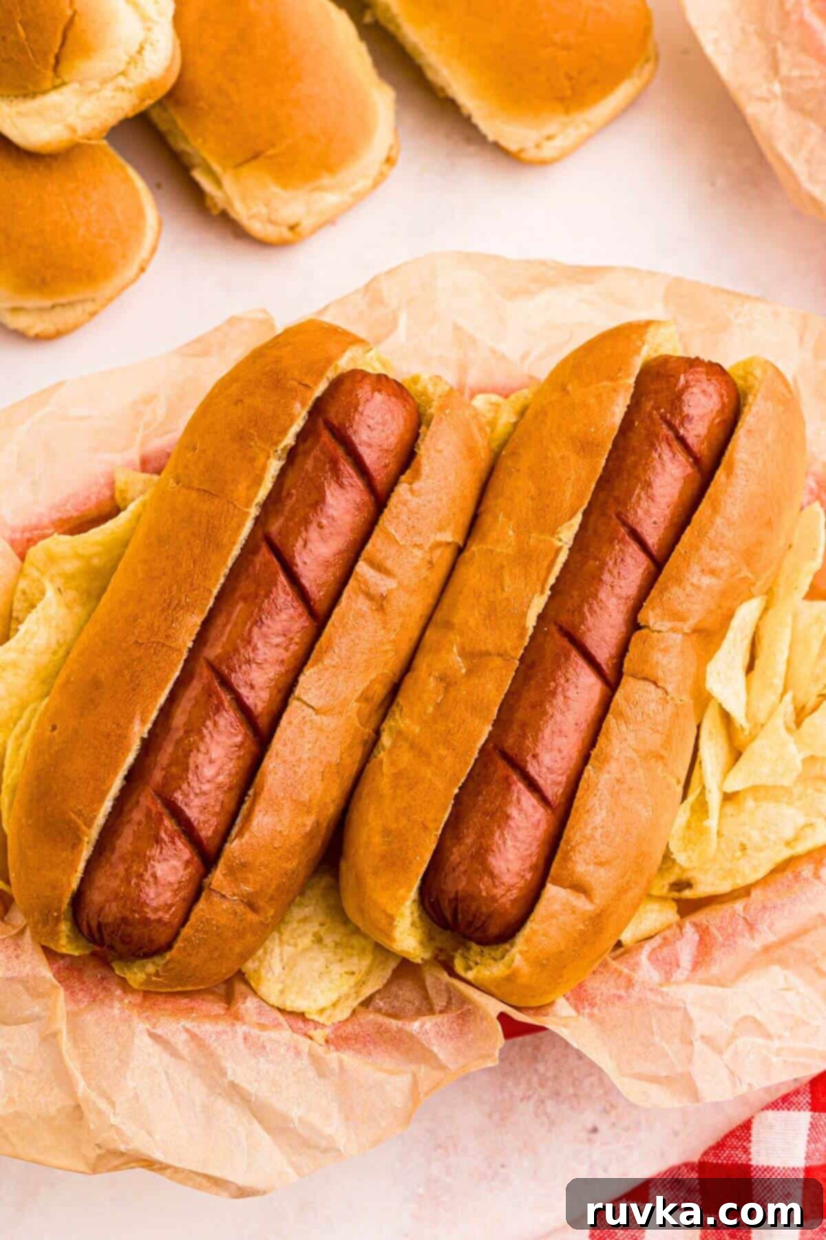Air Fryer Hot Dog Hack 7 Golden juicy hot dogs in buns, with potato chips next to them.