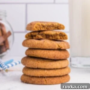 Easy Air Fryer Christmas Cookies 8 Stacked gingersnap cookies in front of milk and cinnamon sticks, highlighting their crisp texture.