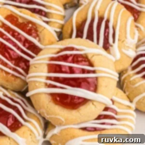 Easy Air Fryer Christmas Cookies 10 Golden cookies topped with seedless jam and drizzled with white chocolate, invitingly arranged.