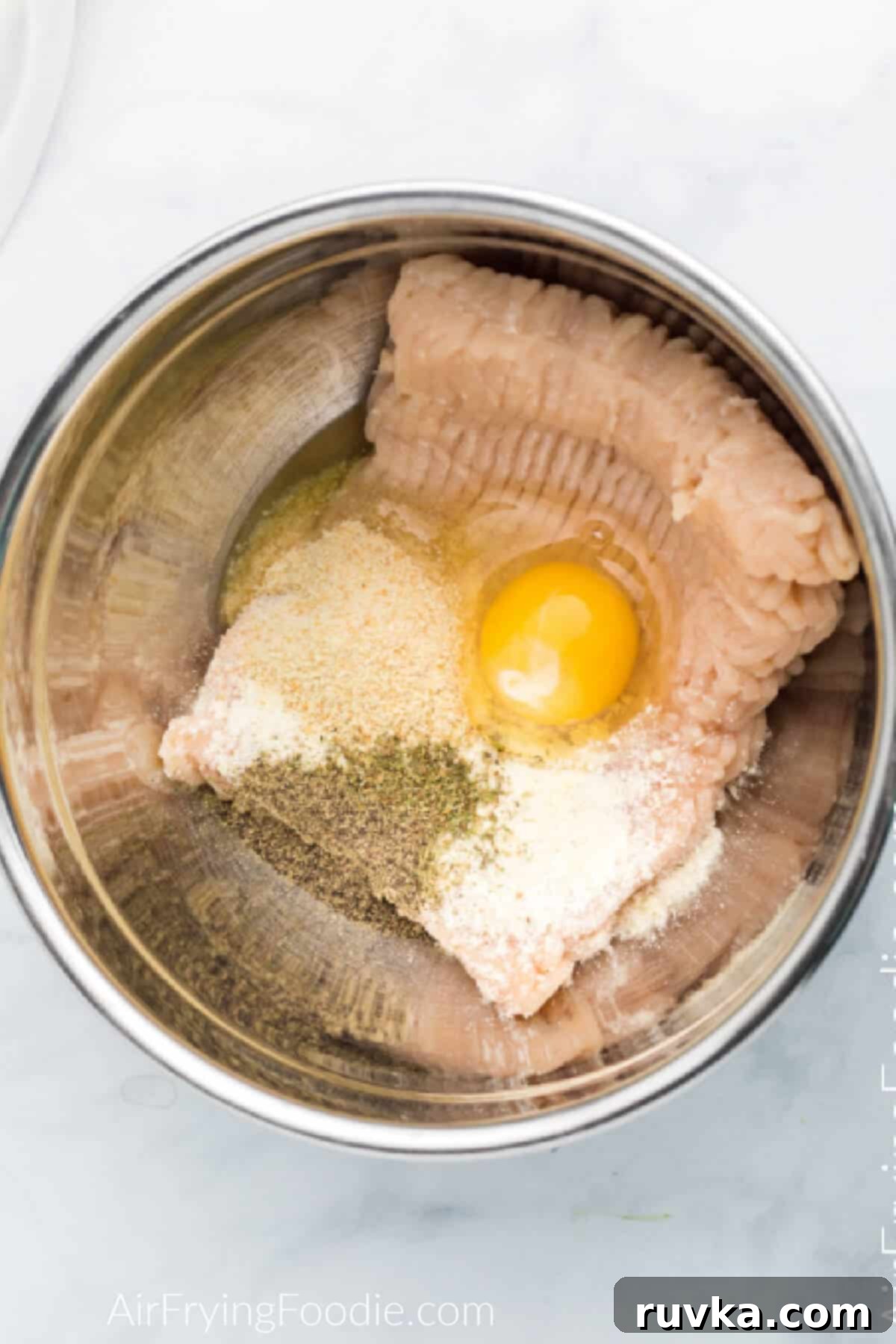 Crispy Air Fryer Chicken Parmesan Meatballs 3 Ingredients in a large mixing bowl used to make chicken meatballs in the air fryer.