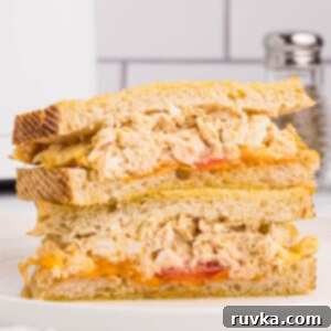 Crispy Air Fryer Tuna Melt 13 Air fryer tuna melt served on golden Texas toast with tomatoes and melted cheese cut in half and served on a round white plate,