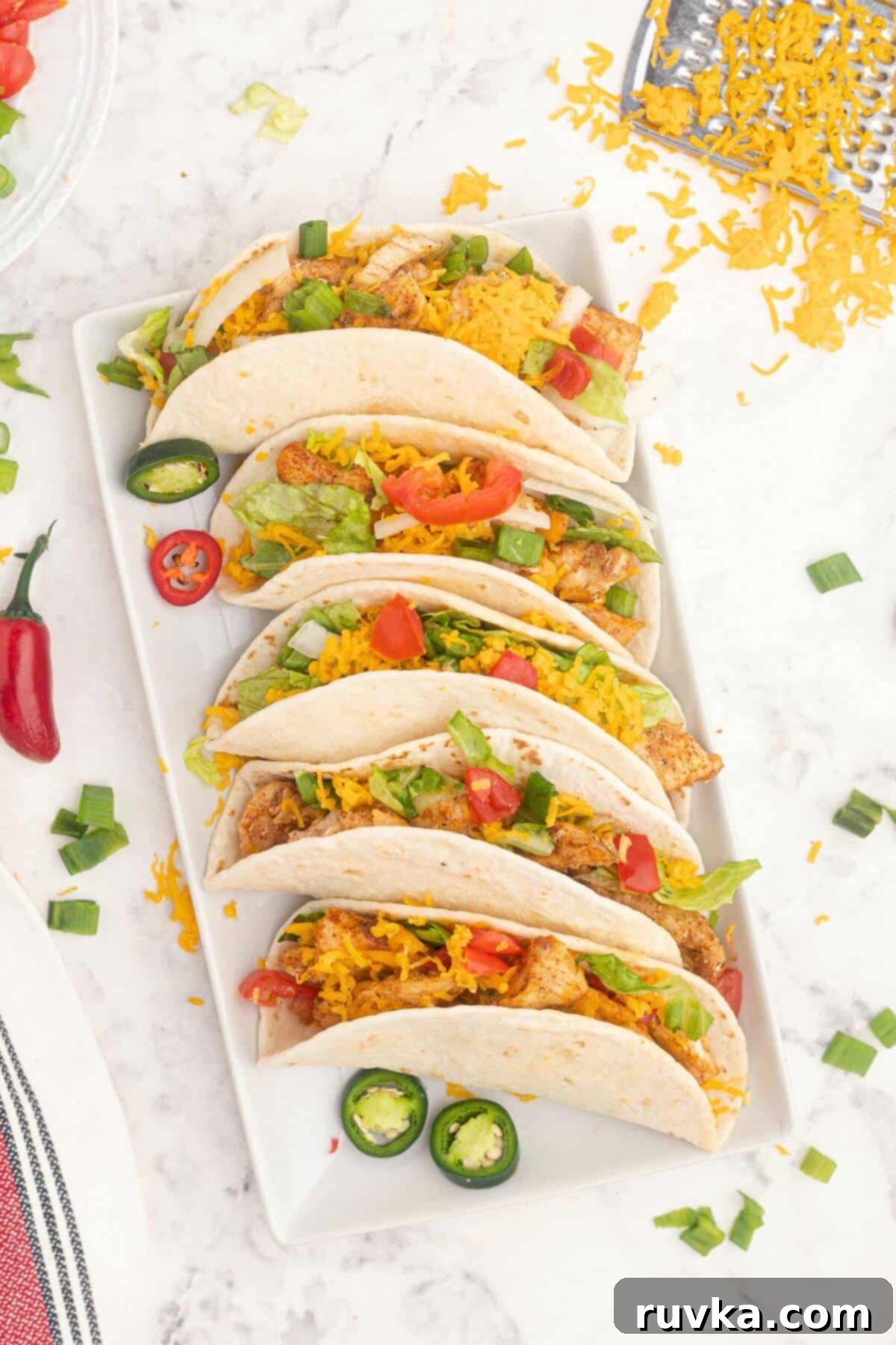 Crispy Air Fryer Chicken Street Tacos 2 Seasoned chicken in flour tortillas on a white rectangle plate.