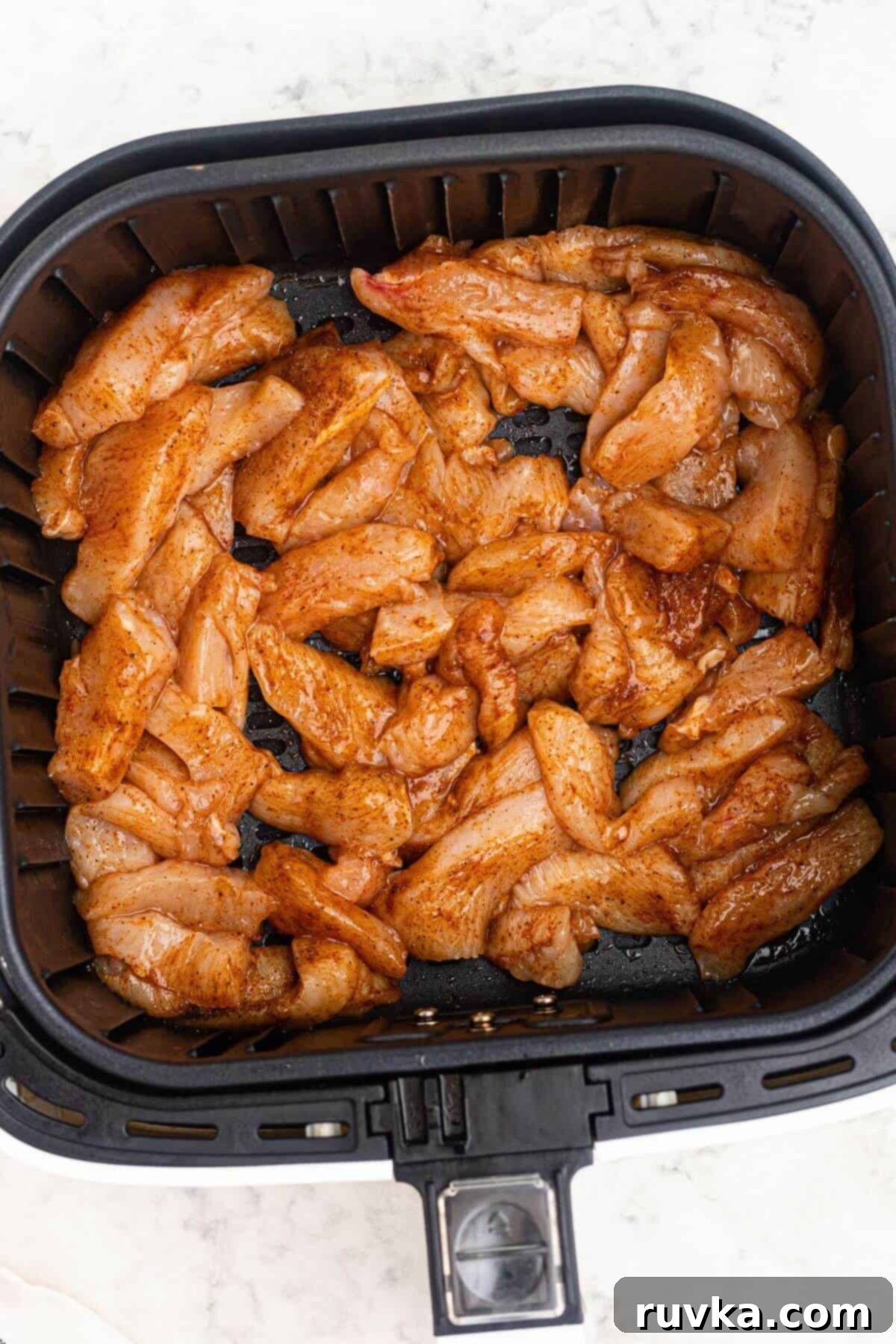 Crispy Air Fryer Chicken Street Tacos 3 Uncooked seasoned chicken in the air fryer basket.