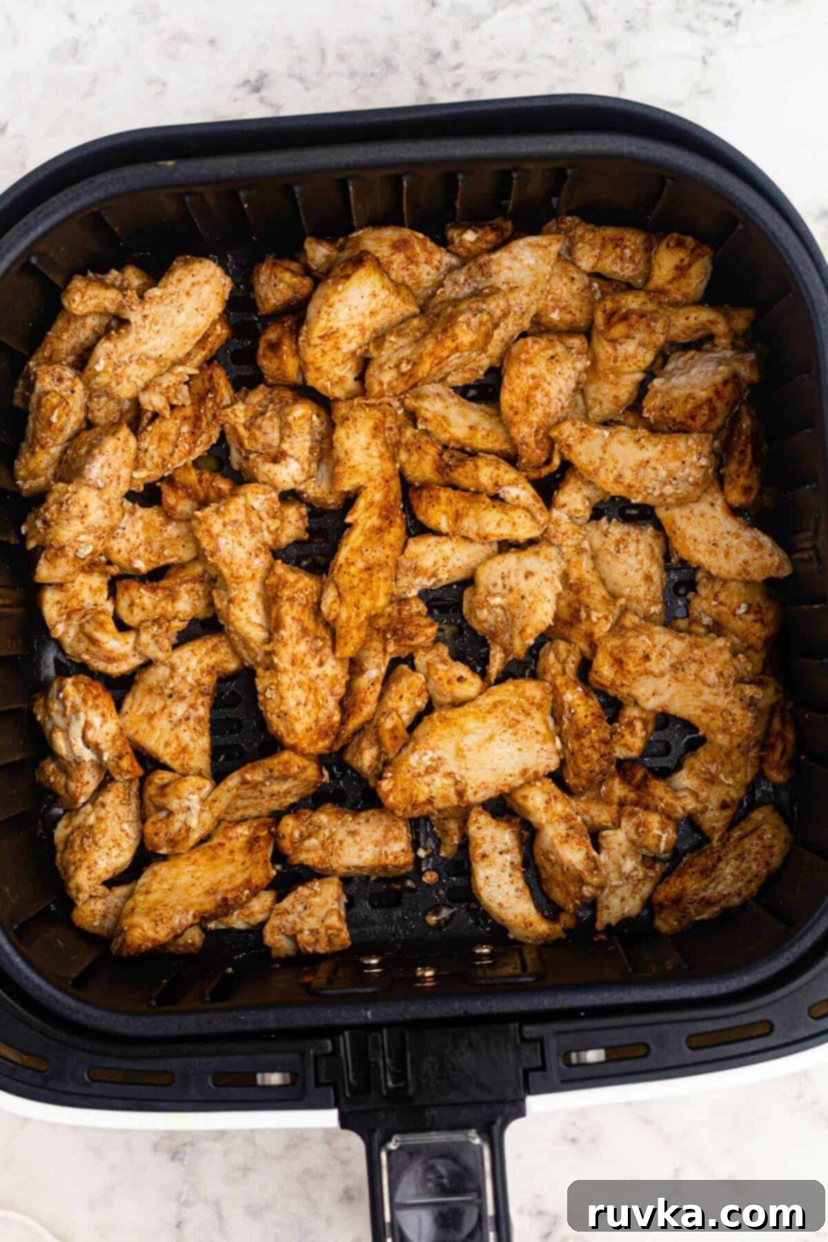 Crispy Air Fryer Chicken Street Tacos 4 Golden brown seasoned and cooked chicken pieces in the air fryer basket.