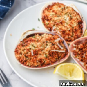 Crispy Air Fryer Stuffed Clams 11 Closeup overhead shot of golden brown air fryer stuffed clams on a white plate, highlighting the crispy breadcrumb topping and fresh garnish.
