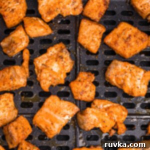 Spicy Air Fryer Blackened Salmon Bites 12 Blackened salmon bites in the basket of an air fryer.