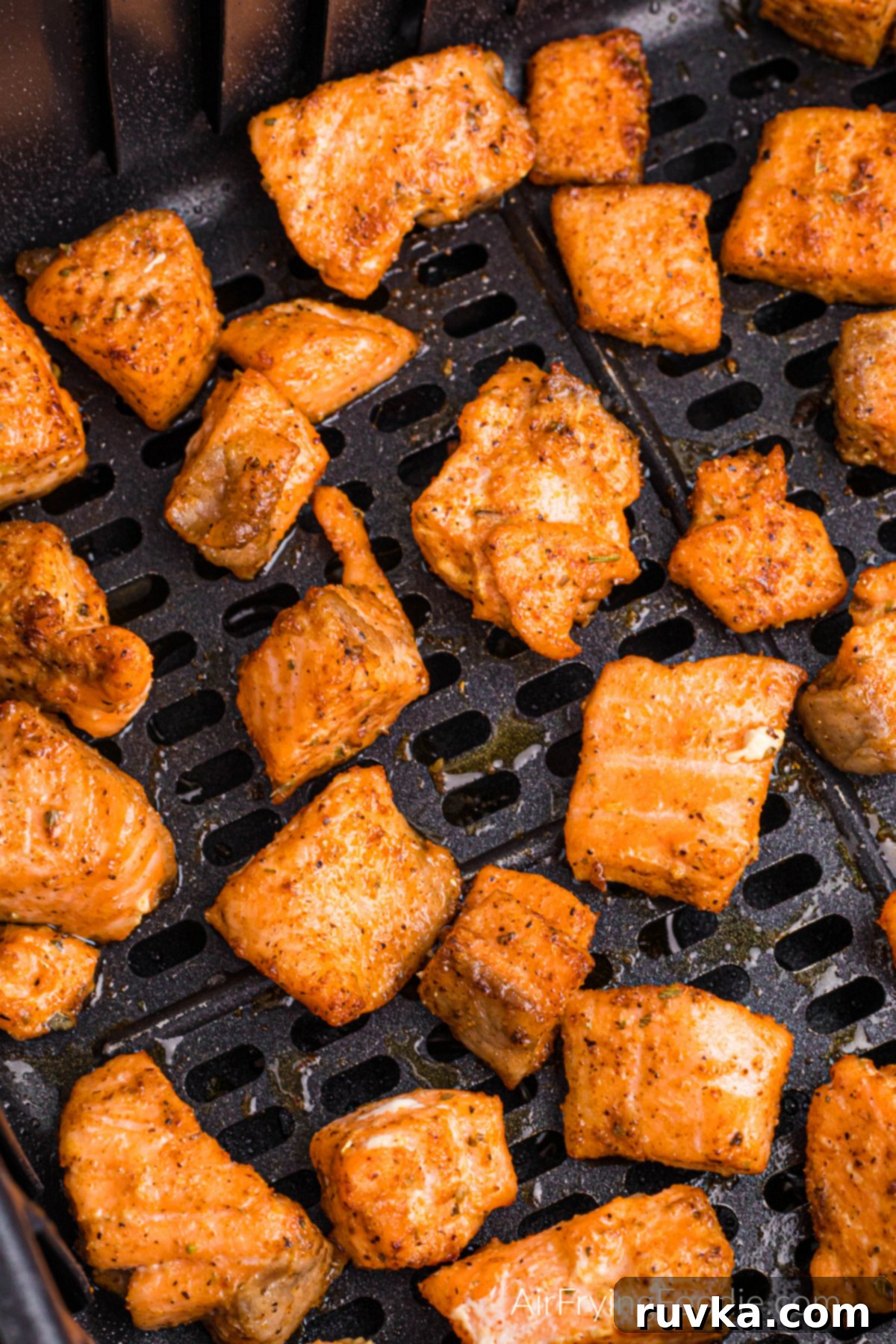 Spicy Air Fryer Blackened Salmon Bites 9 Blackened salmon bites in the basket of the air fryer.