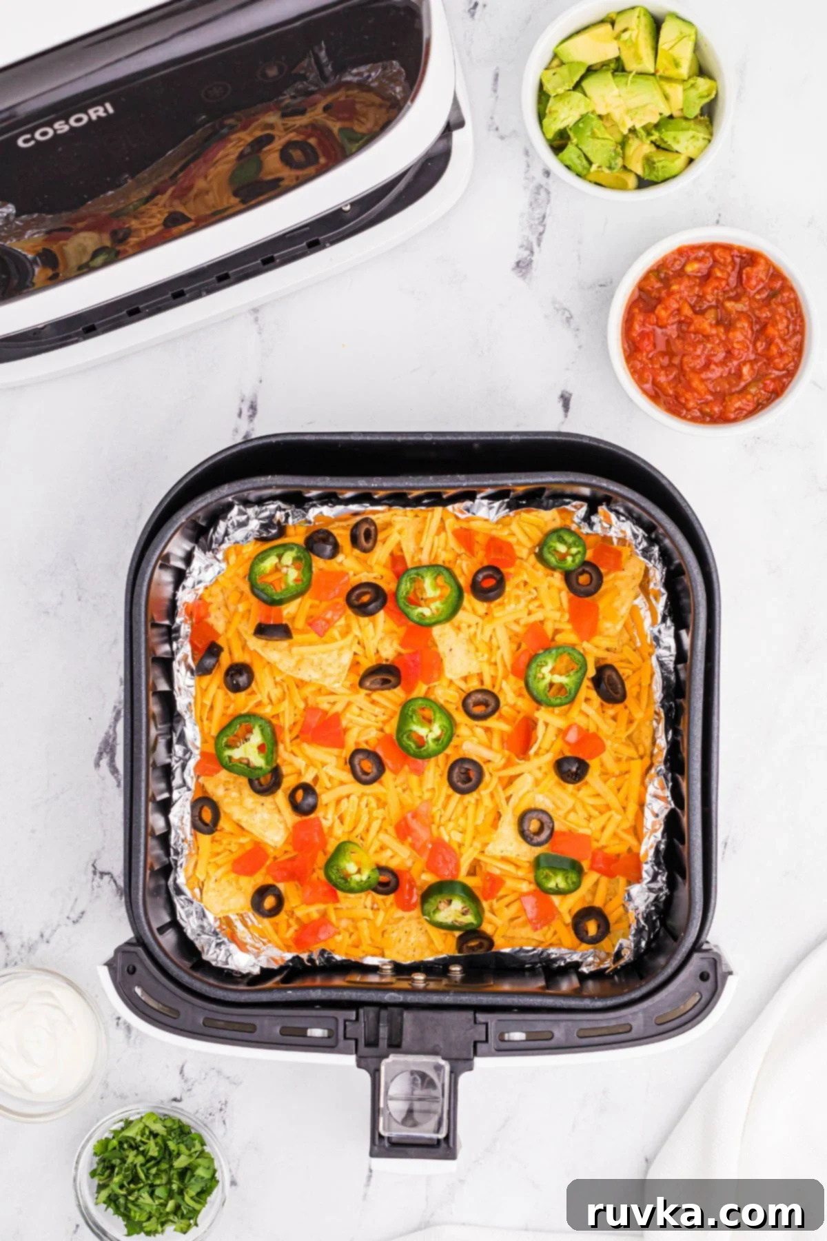 Ultimate Air Fryer Nachos 5 tortilla chips topped with shredded cheddar cheese and favorite nacho toppings.