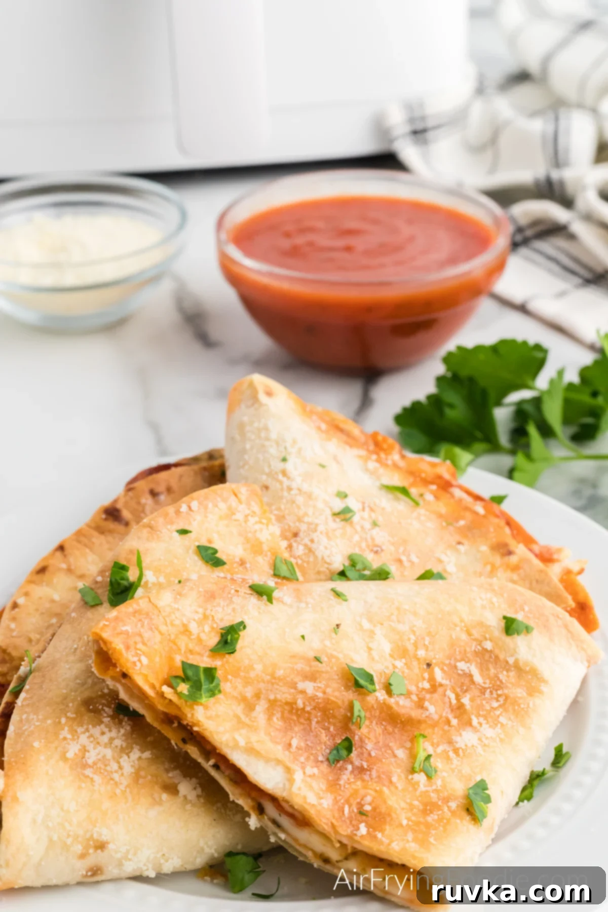 Crispy Air Fryer Pizza Quesadilla 2 Crispy Air Fryer Pizza Quesadilla, served on a plate with fresh parsley garnish.