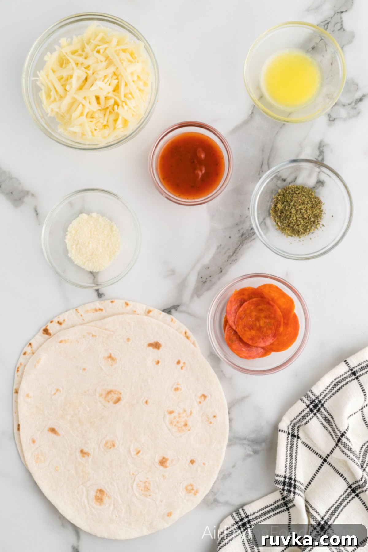 Crispy Air Fryer Pizza Quesadilla 3 Fresh flour tortillas, pepperoni, shredded cheese, and pizza sauce laid out on a wooden board, ready for making pizza quesadillas.