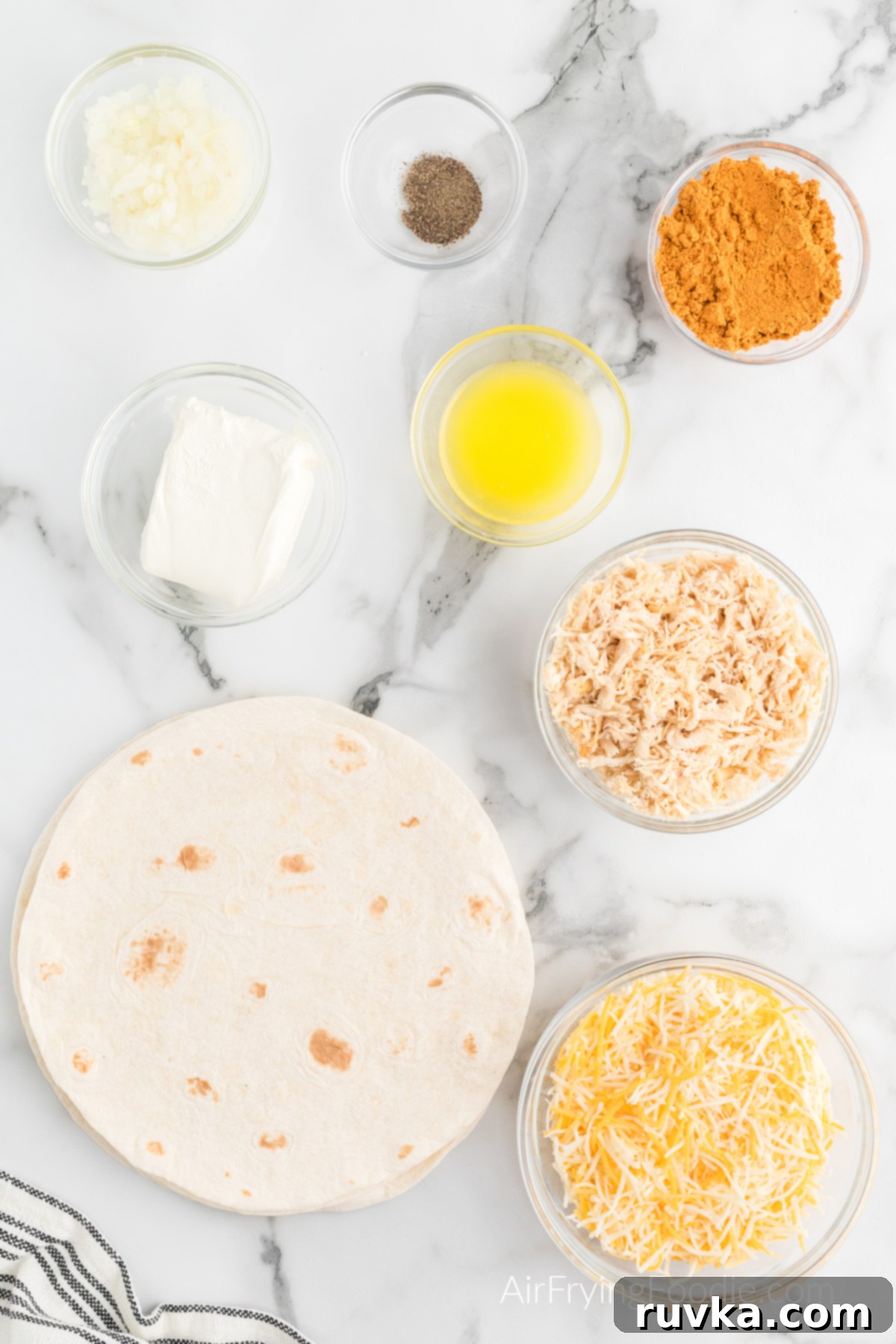 Crispy Air Fryer Chimichangas 3 All the fresh and flavorful ingredients needed to make homemade chimichangas, neatly arranged in bowls on a elegant marble countertop.