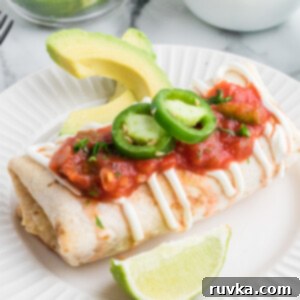 Crispy Air Fryer Chimichangas 10 Air Fryer Chimichanga on a plate with toppings, ready to serve.