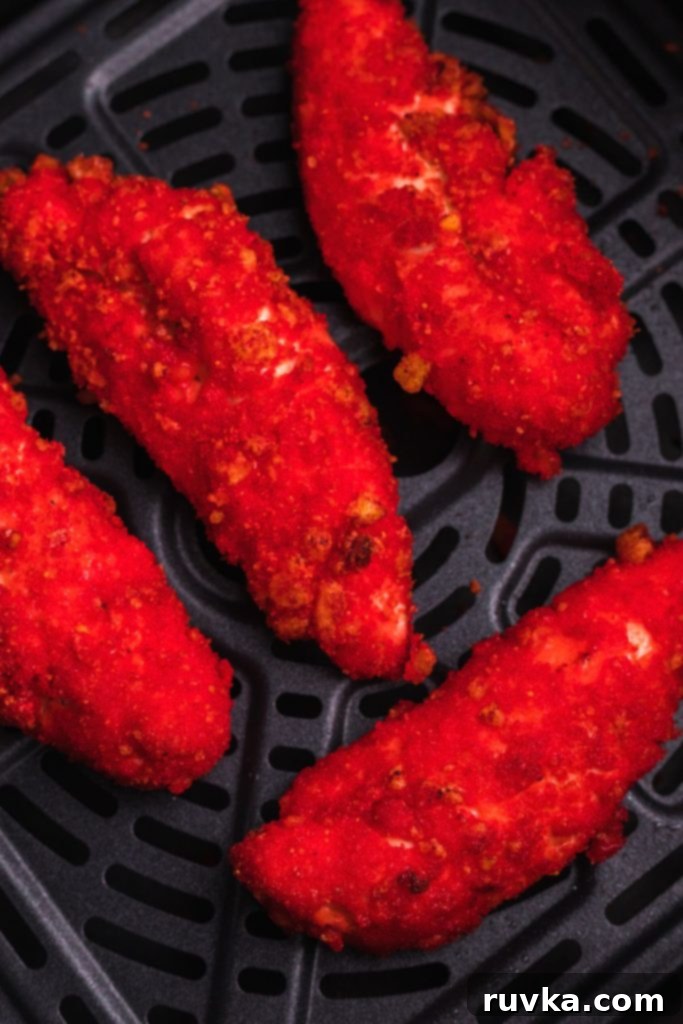 Crispy Air Fried Flamin Hot Cheetos Chicken 8 Red crispy coated chicken in the air fryer basket after being cooked