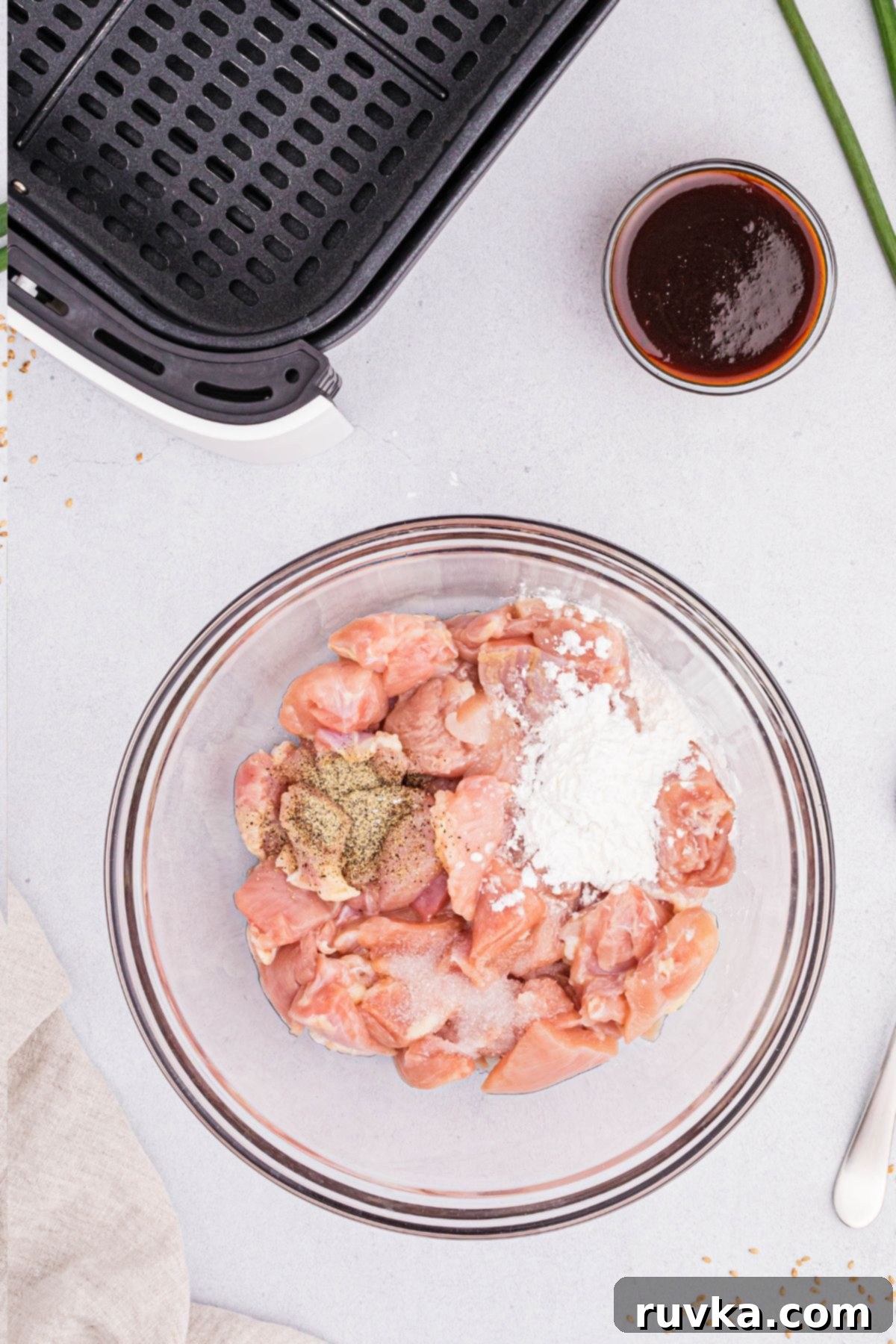 Crispy Air Fryer General Tso's Chicken 4 Chicken mixed with cornstarch and seasonings in a clear glass bowl