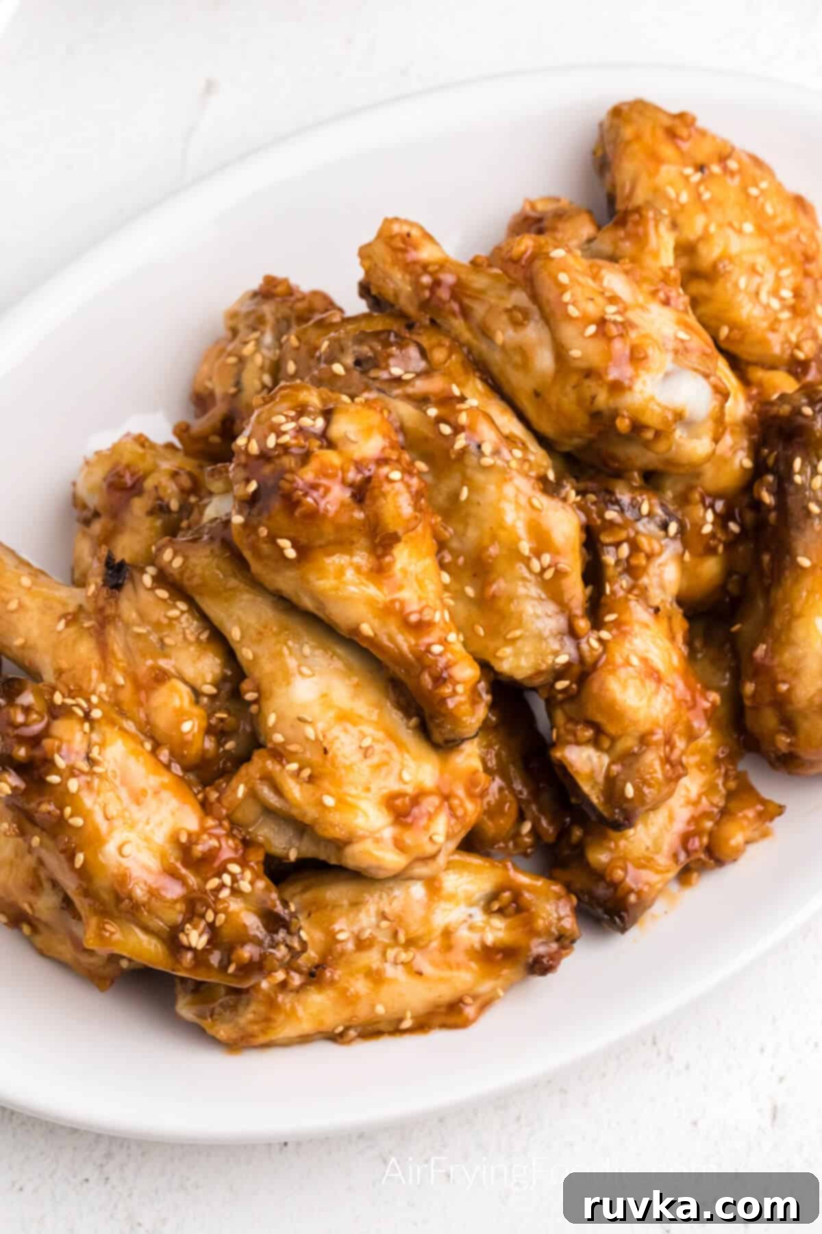 Crispy Honey Garlic Air Fryer Wings 3 Honey garlic chicken wings on a white plate ready to serve.