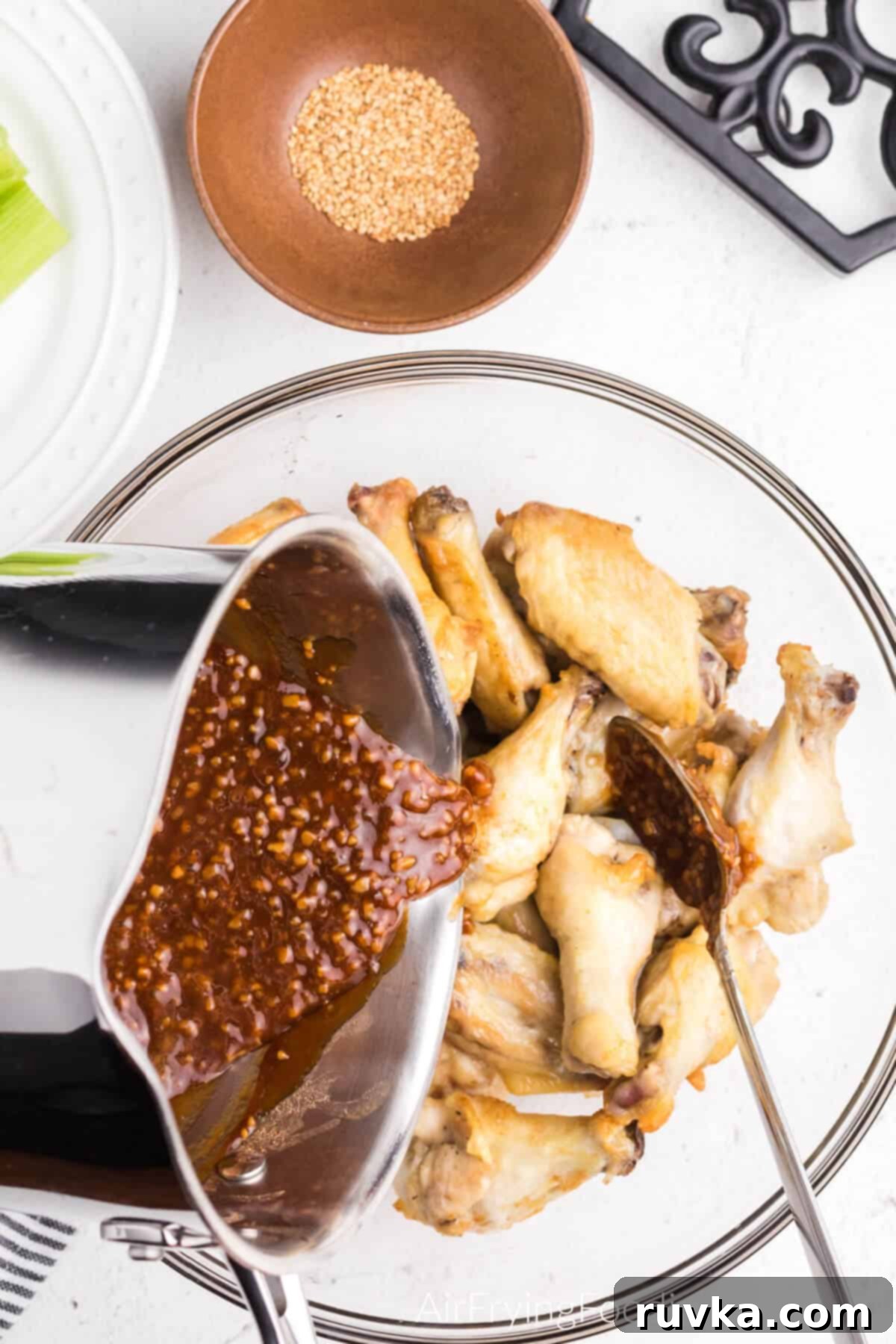 Crispy Honey Garlic Air Fryer Wings 8 Sauce being poured over the chicken wings.