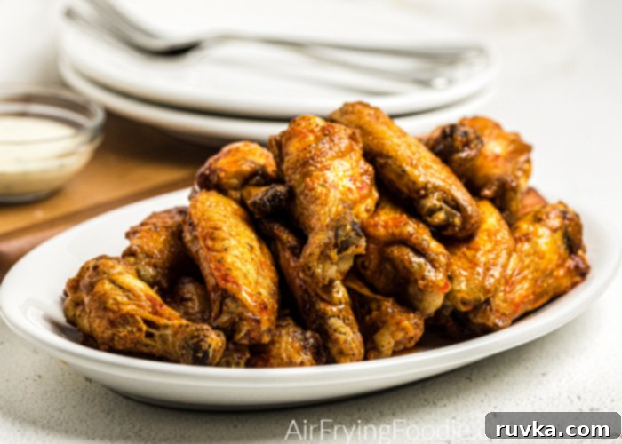 Crispy Air Fryer Buffalo Wings 3 Buffalo Chicken Wings on a white plate ready to serve.