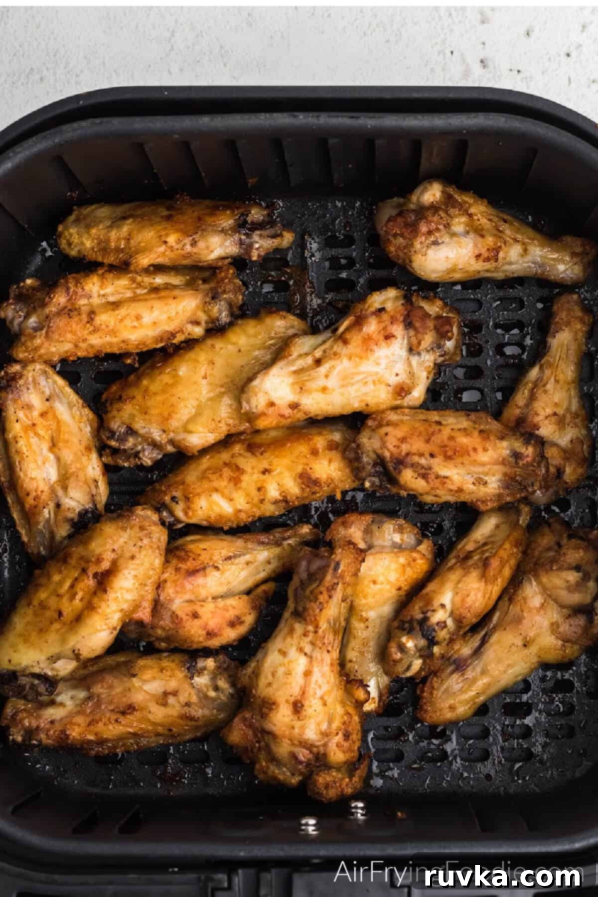 Crispy Air Fryer Buffalo Wings 8 Chicken wings in air fryer basket, cooked and ready to be tossed in sauce.