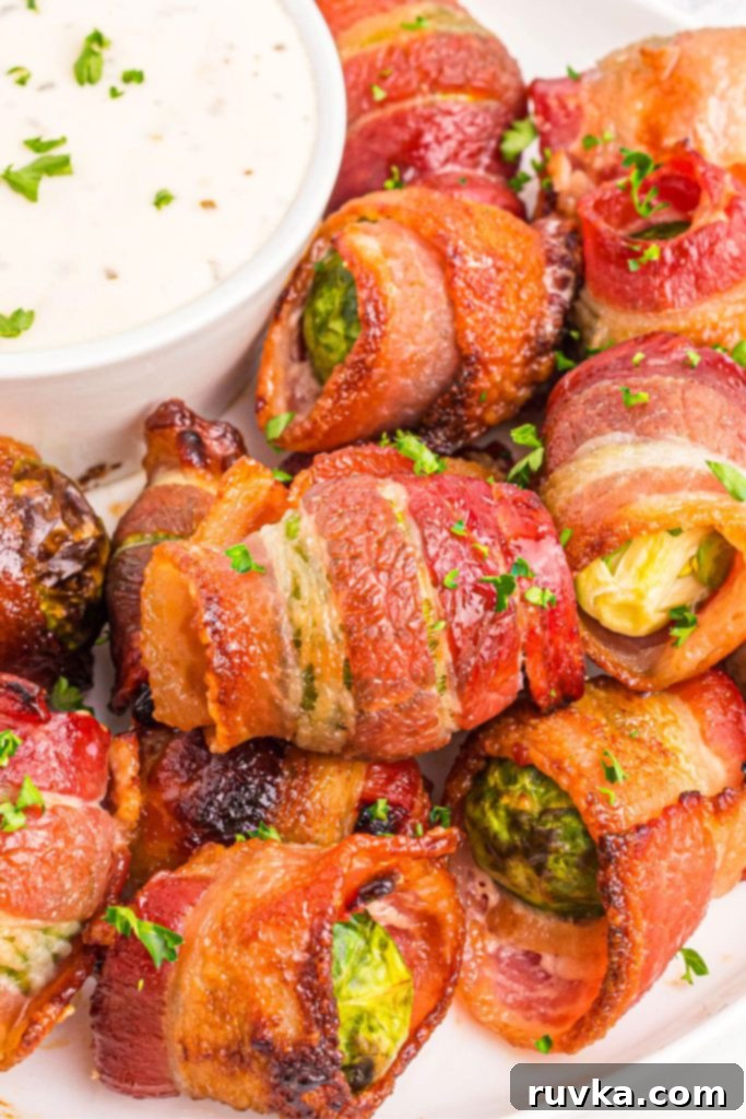 Crispy Air Fryer Bacon Brussels Bites 8 Crispy golden bacon wrapped around brussels sprouts on a white plate