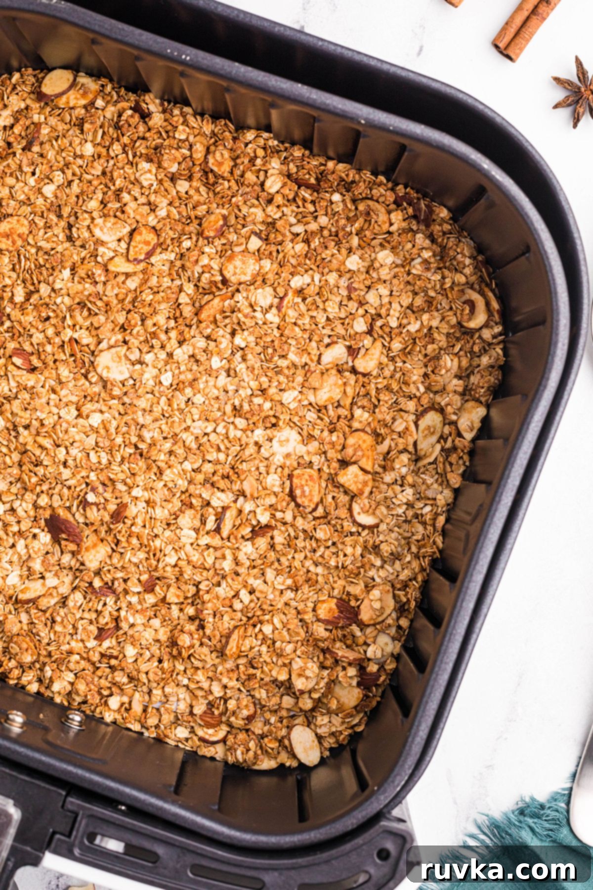 Easy Air Fryer Granola 6 golden brown oats with nuts after being cooked in the air fryer basket.