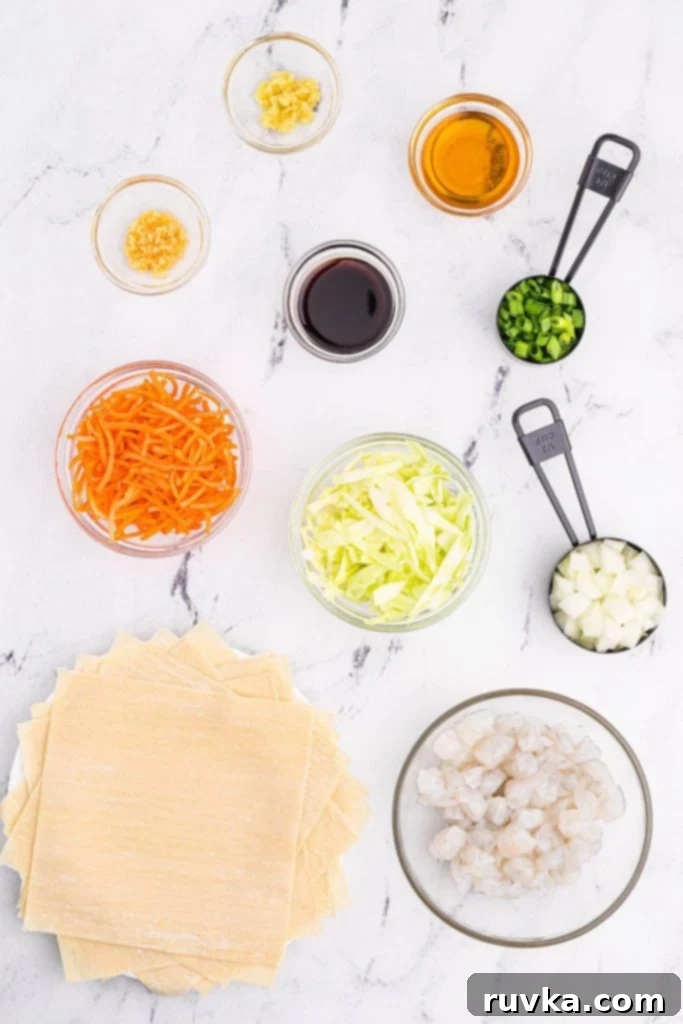 Crispy Air Fryer Shrimp Egg Rolls 3 Ingredients needed to make shrimp egg rolls measured out in mixing bowls on a white marble table