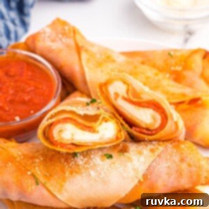 Crispy Air Fryer Pizza Egg Rolls 11 Golden crispy pizza egg rolls stacked on a white plate served with pizza sauce.
